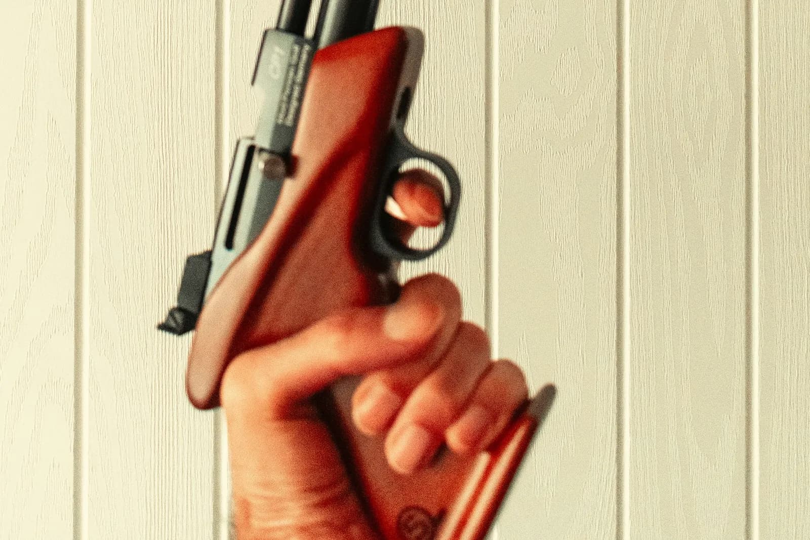 Main tenant la poignée en bois d'un pistolet de tir à air comprimé