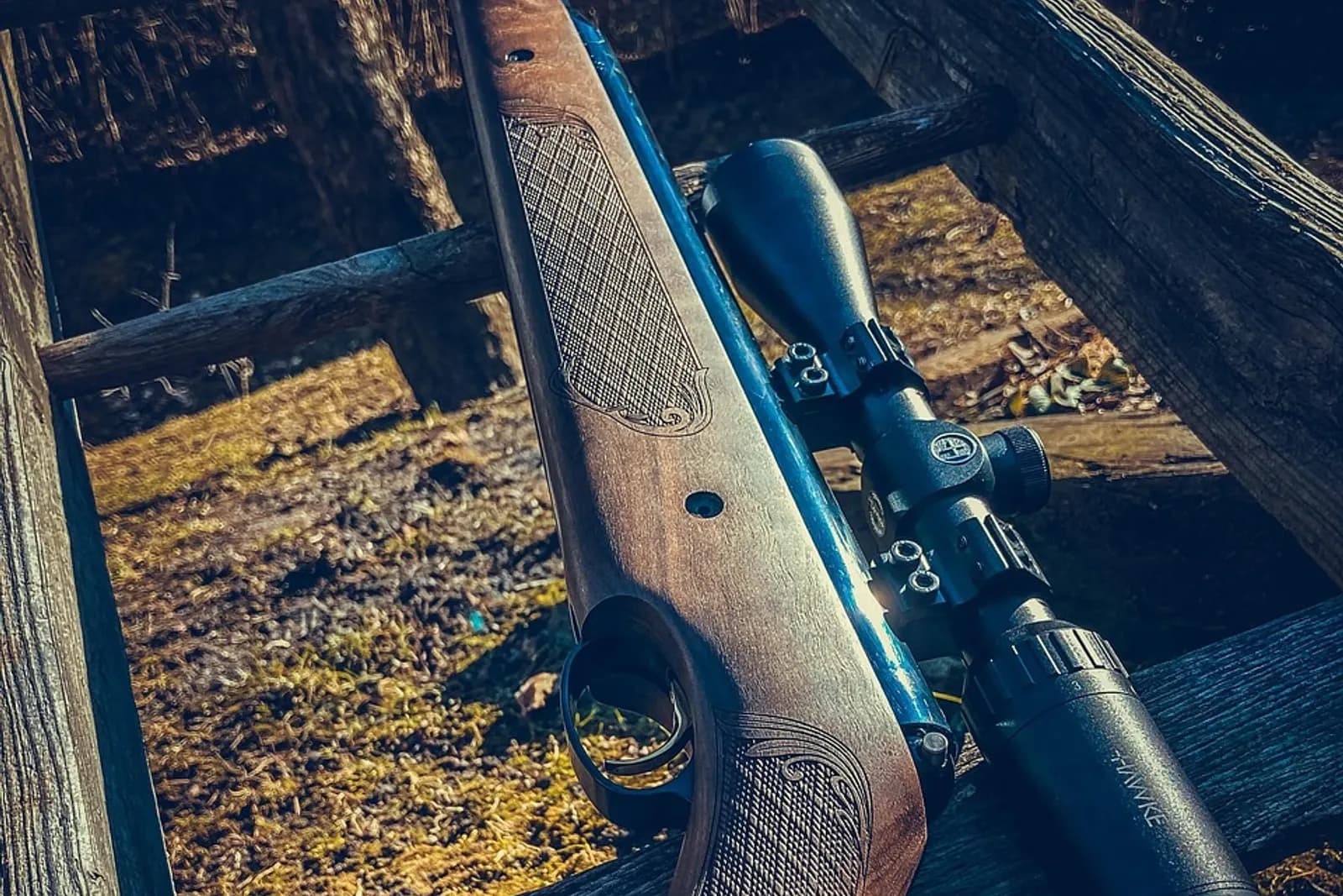Carabine à crosse en bois et lunette posée sur un banc de tir