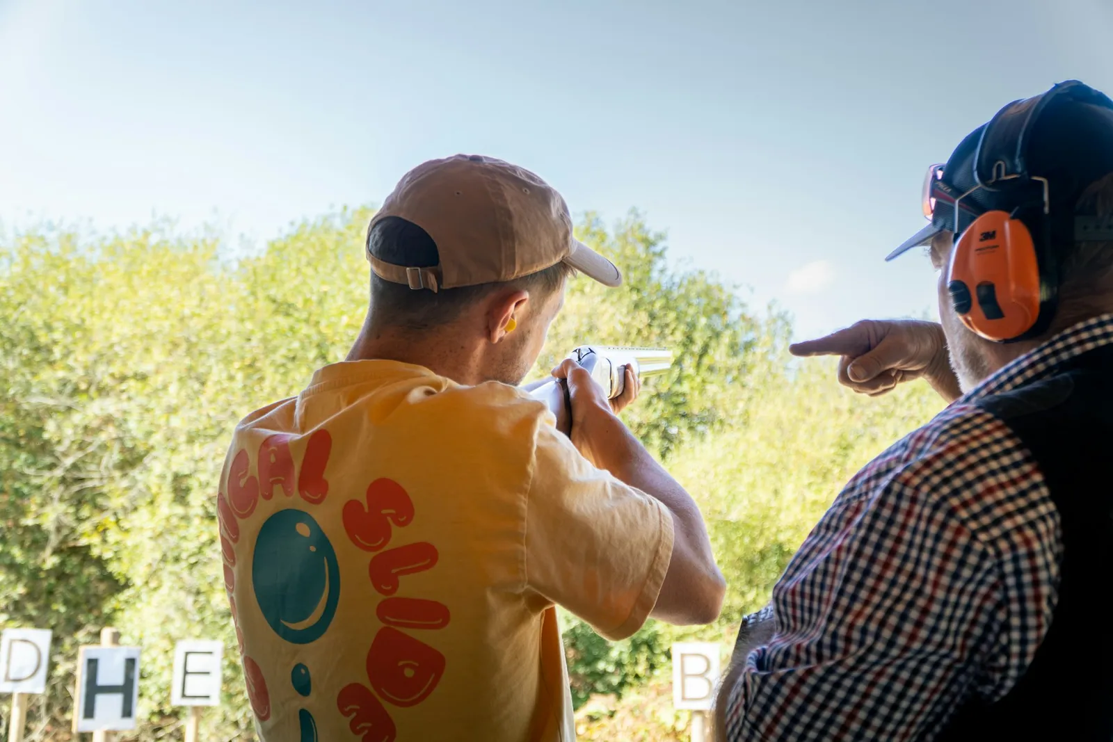 Instructeur donnant des conseils à un tireur débutant au moment de la visée