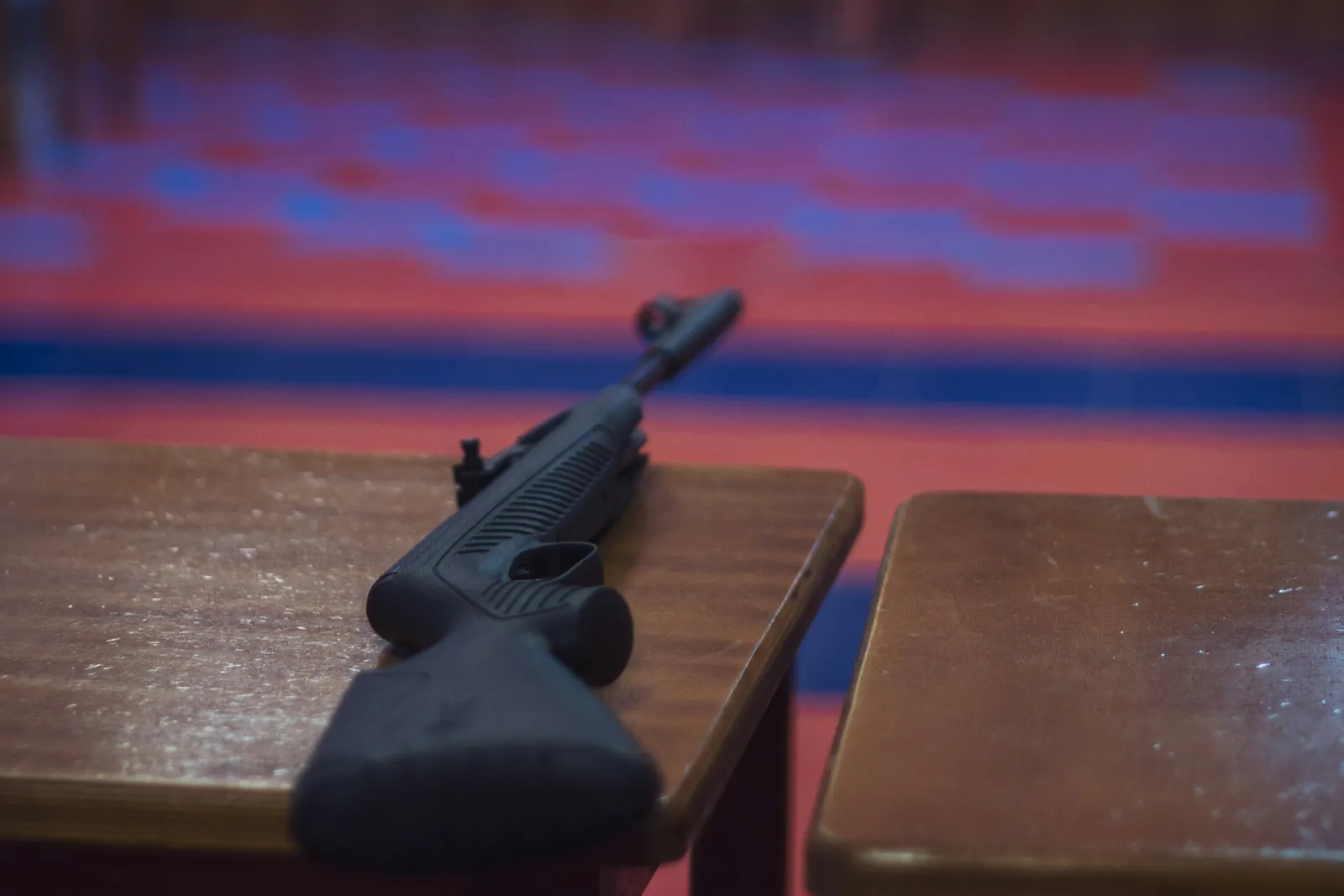 Carabine à air comprimé posée sur une table de tir dans un stand à 10 mètres