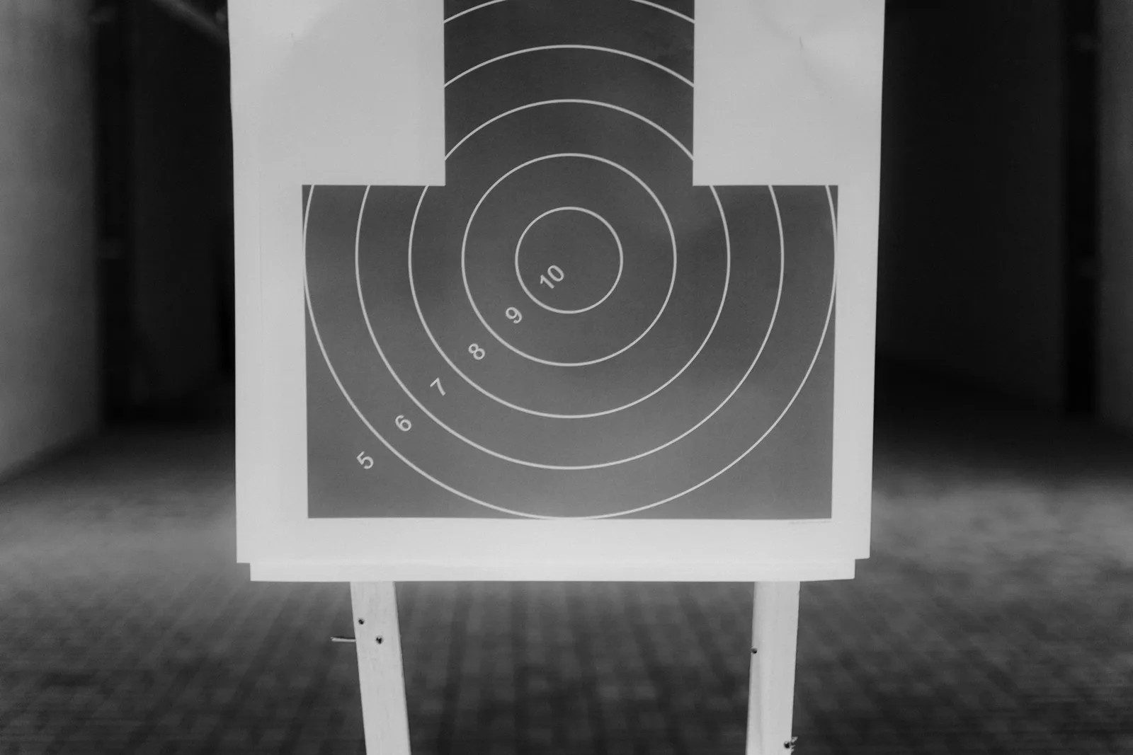 Cible de tir sportif à anneaux numérotés au bout d'un couloir de tir, en noir et blanc