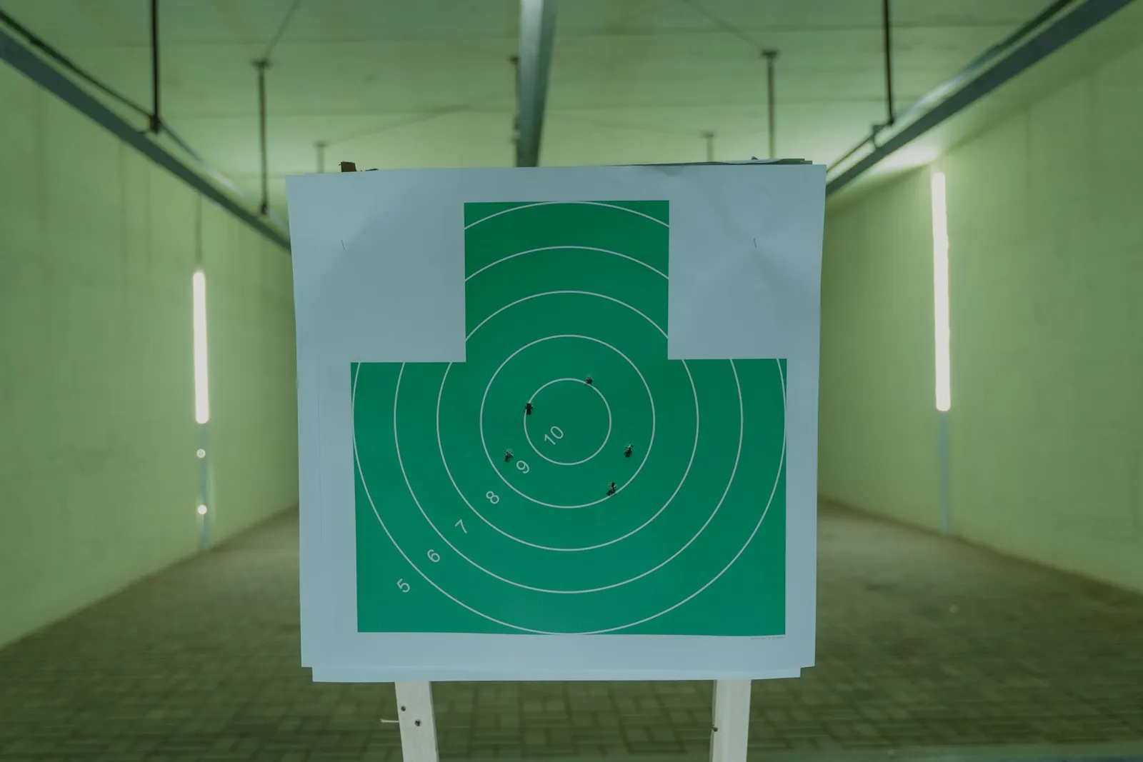 Cible verte à anneaux numérotés placée au bout d'un couloir de tir couvert